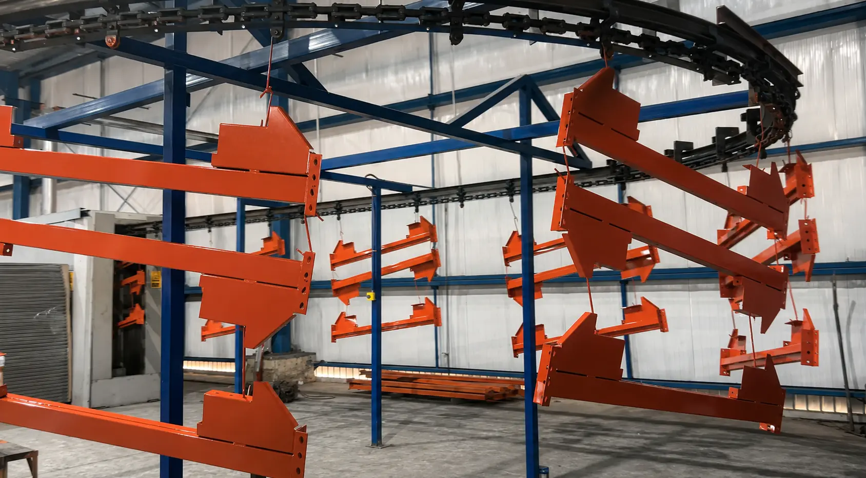Componentes estructurales con acabado naranja recorriendo la línea de pintura de SMACERO